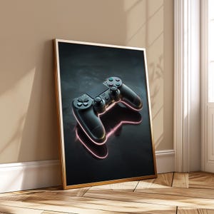 Peut inclure: Impression encadrée d'une manette de jeu noire avec des boutons bleus et noirs. La manette est posée sur un fond sombre avec un contour néon rose, créant une esthétique moderne. Le cadre est doré.