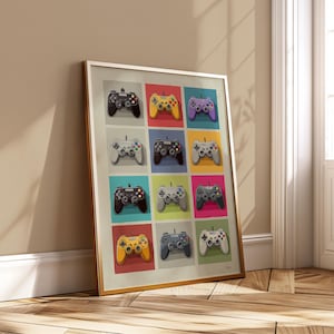 Op de afbeelding: Een ingelijste kunstdruk met een raster van kleurrijke videogamecontrollers. Elke controller heeft een andere kleur, waaronder zwart, geel, paars, grijs en wit. De controllers staan tegen een achtergrond van verschillende kleuren, zoals blauw, groen en roze.