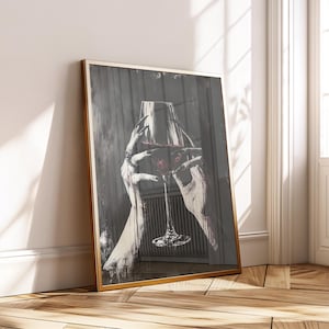May include: Framed art print featuring a grayscale illustration of hands holding a wine glass filled with red liquid. The hands are detailed with long nails and jewelry, set against a dark, textured background.