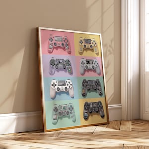 May include: A framed print featuring six colorful game controllers arranged in a grid. The controllers are in various colors, including pink, yellow, white, and black, set against a pastel background. The print is displayed in a gold frame.