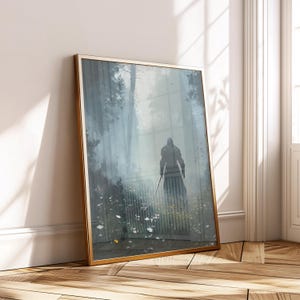 Pode incluir: Uma impressão de arte emoldurada com uma figura com uma espada em uma cena de floresta nebulosa. A obra de arte tem uma moldura dourada e está encostada em uma parede branca. A cena é renderizada em tons de cinza, branco e verde.