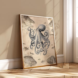 May include: Framed vintage-style print featuring a detailed illustration of an octopus surrounded by various fish. The artwork is in grayscale with a sepia-toned background, and is encased in a gold frame. The print is leaning against a wall.