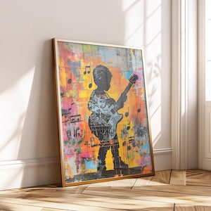 Op de afbeelding: Een ingelijste kunstdruk met een silhouet van een kind dat een elektrische gitaar bespeelt. De achtergrond is een kleurrijke, abstracte mix met muzieknoten. De lijst is goudkleurig en de stijl is modern en artistiek.