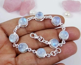 May include: A silver bracelet with a chain link design and round moonstone gemstones. The bracelet has a lobster clasp closure.