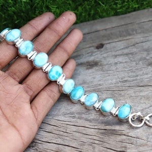 Peut inclure: Un bracelet en argent avec des perles ovales de pierres précieuses bleues et vertes. Le bracelet a un fermoir en argent.