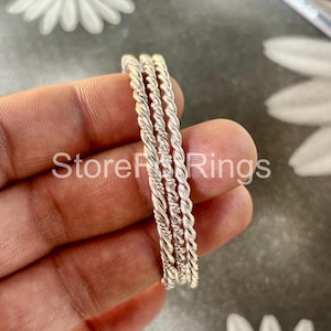 May include: Three silver bangles with a twisted rope design.