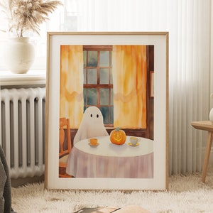 May include: A watercolour painting of a ghost sitting at a table with a pumpkin and two teacups. The ghost is white and has two black eyes. The pumpkin is orange and has a carved smiley face. The teacups are white with gold trim. The table is covered in a white tablecloth. The background is a watercolour painting of a window with yellow curtains.