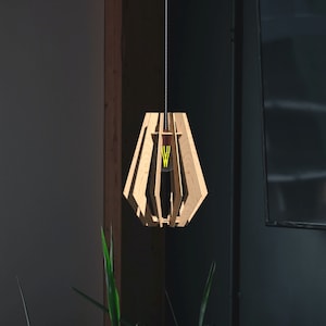 May include: A wooden pendant light fixture with a geometric design. The light fixture is hanging from a wire and has a light bulb inside.