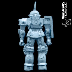 K&ouml;nnte beinhalten: Hellblaue Spielzeug-Roboterfigur mit Schild und einzelner Antenne. Der Roboter hat detaillierte mechanische Merkmale und japanischen Text auf Beinen und Torso. Der Hintergrund ist tiefschwarz.