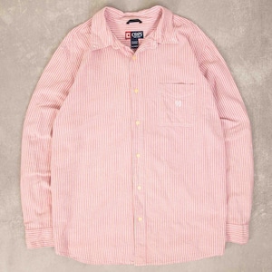 Peut inclure: Chemise à manches longues à rayures verticales roses et blanches. La chemise a une poche poitrine avec un petit logo et la marque "CHAPS" sur le col.