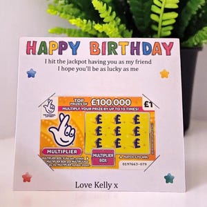 Könnte beinhalten: Eine Geburtstagskarte mit den Worten "HAPPY BIRTHDAY" in bunten Buchstaben. Die Karte enthält eine Lotterie-Ticket-Grafik mit dem Text "TOP PRIZE OF £100,000" und der Nachricht "I hit the jackpot having you as my friend".