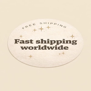 Peut inclure: Un autocollant ovale avec l'inscription "Free Shipping" en haut et "Fast shipping worldwide" en gras. L'autocollant a un fond blanc cass&eacute; textur&eacute; avec des accents d'&eacute;clats d'&eacute;toiles.