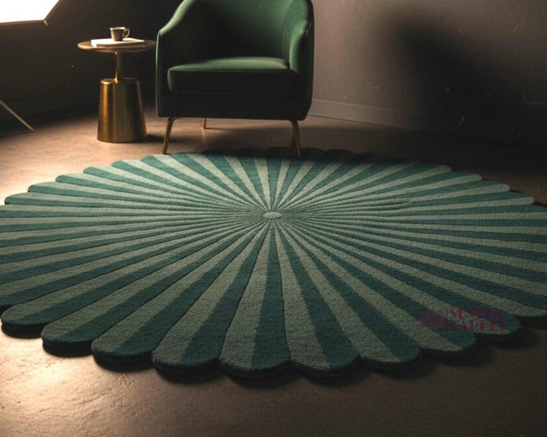A round green rug with a scalloped edge and alternating radial sunburst stripes is laid out on a dark floor in a dimly lit room featuring a green armchair and small side table.