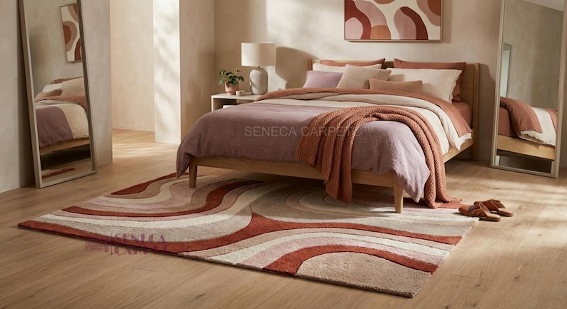 May include: A rectangular area rug featuring a layered, wavy pattern in shades of terracotta, cream, and beige. The rug has a textured, tufted surface with curved lines that create a rhythmic, flowing design across the entire floor covering.