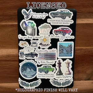 May include: A collection of stickers featuring various designs, including cars, a lighter, a cloud, a sun, a mountain range, a waterfall, a chess set, and wings. The stickers have a holographic finish and include text such as "We love rainy days, don't we baby?" and "Can you keep a secret?"
