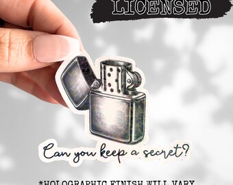 May include: A silver lighter with a holographic finish and the text "Can you keep a secret?"  *HOLOGRAPHIC FINISH WILL VARY*