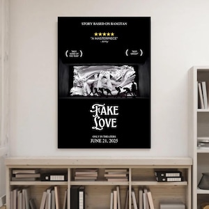 Op de afbeelding: Zwart filmaffiche met de titel "FAKE LOVE" in witte letters. De poster bevat de tekst "STORY BASED ON BANGTAN" en "JUNE 21, 2025." Een zwart-wit afbeelding van figuren staat in het midden. De poster wordt op een witte muur weergegeven.