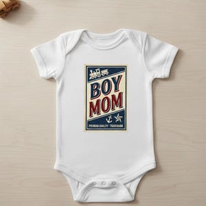Puede incluir: Body de beb&eacute; blanco con un gr&aacute;fico azul marino y rojo que dice "BOY MOM". El dise&ntilde;o incluye un tren, un ancla y una estrella. Tambi&eacute;n se incluye el texto "PREMIUM QUALITY - TRADEMARK".