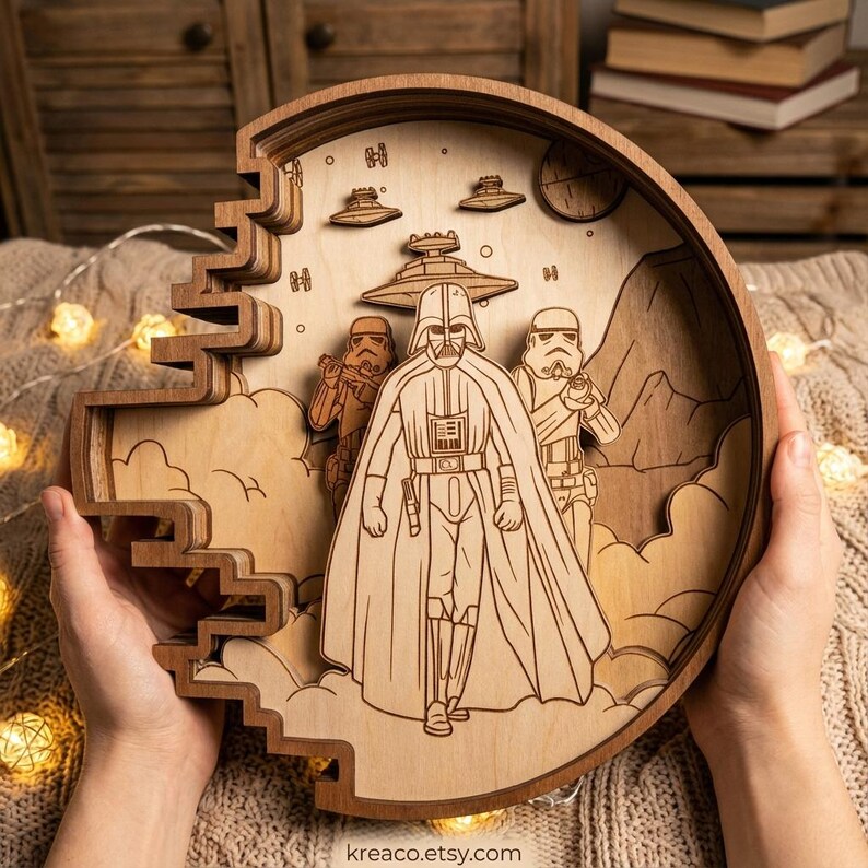 May include: A layered wooden artwork featuring Darth Vader and Stormtroopers from Star Wars. The circular design includes spaceships, clouds, and a planet. The artwork is held by hands and has the Etsy shop name "kreaco.etsy.com" at the bottom.