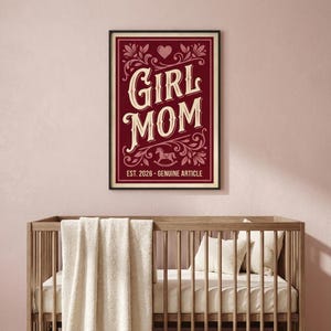 Puede incluir: Un estampado enmarcado con las palabras "GIRL MOM" en un estilo vintage, con elementos florales decorativos y una ilustraci&oacute;n de un caballito balanc&iacute;n. El estampado est&aacute; en un marco rojo oscuro e incluye el texto "EST. 2026 - GENUINE ARTICLE".