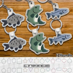May include: A set of five embroidered keychains featuring different fish designs. The keychains are made of felt and have a white background. The fish designs include a green bass, a grey carp, a blue trout, and two different green bass designs. The keychains are perfect for anglers or anyone who loves fish.