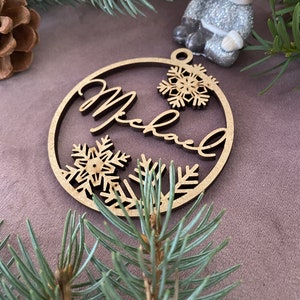 Pu&ograve; includere: Un ornamento natalizio in legno con il nome "Michael" inciso. L'ornamento &egrave; decorato con fiocchi di neve e ha un foro nella parte superiore per appenderlo.