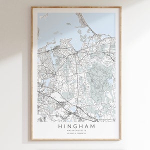 May include: A black and white map print of Hingham, Massachusetts with a light blue background. The map shows the streets and bodies of water in the area. The text "Hingham, Massachusetts 42.2459° N, 70.8889° W" is printed below the map.