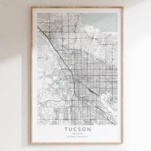 May include: A black and white map print of Tucson, Arizona. The map shows the city streets and surrounding areas. The text "TUCSON ARIZONA 32.2149° N, 110.9747° W" is printed at the bottom of the map.