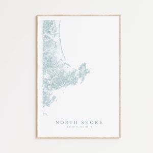 May include: A minimalist print of a map of the North Shore, a coastal region in Massachusetts, with the coordinates 42.7346° N, 70.8396° W printed below the map.