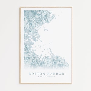 May include: A framed print of a blue and white map of Boston Harbor. The map is a stylized illustration of the harbor and surrounding area. The text "BOSTON HARBOR" and the coordinates "42.3255° N, 70.9509° W" are printed below the map.