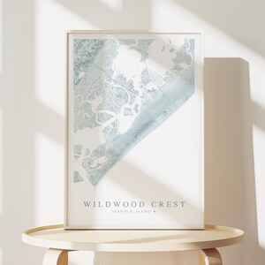 Puede incluir: Una impresi&oacute;n enmarcada de un mapa azul y blanco de Wildwood Crest, Nueva Jersey. El mapa muestra la costa y las v&iacute;as fluviales circundantes. El texto "Wildwood Crest" y las coordenadas "38.9717&deg; N, 74.8187&deg; W" est&aacute;n impresas debajo del mapa.