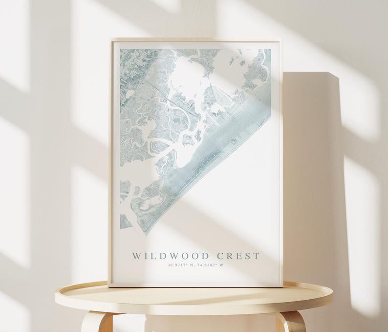 Puede incluir: Una impresi&oacute;n enmarcada de un mapa azul y blanco de Wildwood Crest, Nueva Jersey. El mapa muestra la costa y las v&iacute;as fluviales circundantes. El texto "Wildwood Crest" y las coordenadas "38.9717&deg; N, 74.8187&deg; W" est&aacute;n impresas debajo del mapa.
