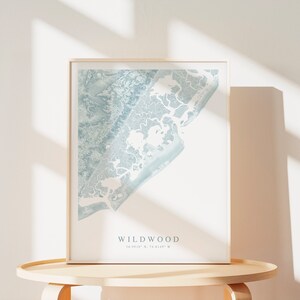 Może przedstawiać: Wydruk w ramie jasnoniebieskiej mapy Wildwood w stanie New Jersey. Mapa przedstawia linię brzegową i otaczające ją drogi wodne. Pod mapą nadrukowano tekst "Wildwood" i wsp&oacute;łrzędne "39.0615&deg; N, 74.8189&deg; W".