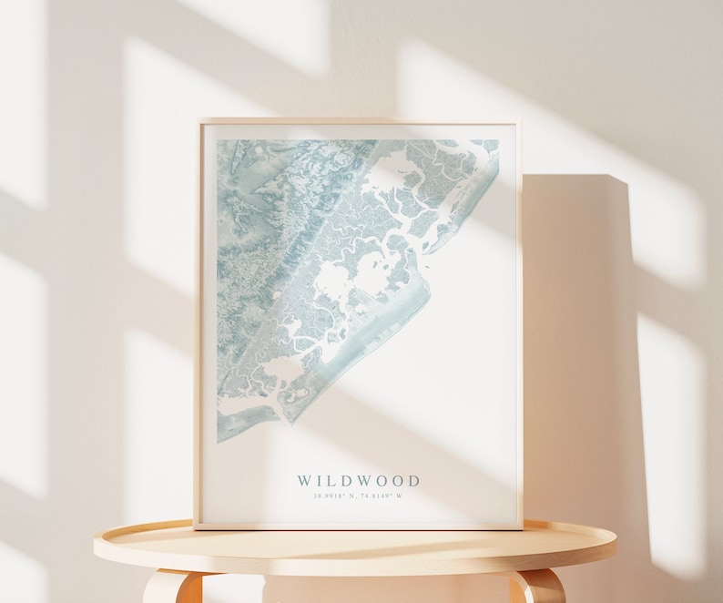 Może przedstawiać: Wydruk w ramie jasnoniebieskiej mapy Wildwood w stanie New Jersey. Mapa przedstawia linię brzegową i otaczające ją drogi wodne. Pod mapą nadrukowano tekst "Wildwood" i wsp&oacute;łrzędne "39.0615&deg; N, 74.8189&deg; W".