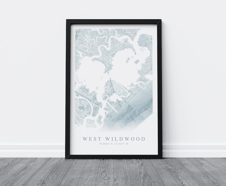 May include: A framed map print of West Wildwood, featuring a detailed, light blue and white topographical design. The print is encased in a black frame and includes the text "WEST WILDWOOD" and coordinates.