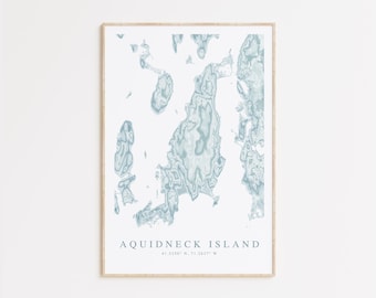 May include: A framed print of a blue and white map of Aquidneck Island, Rhode Island. The map shows the island's coastline and interior features. The text "Aquidneck Island 41.5230° N, 71.2457° W" is printed below the map.