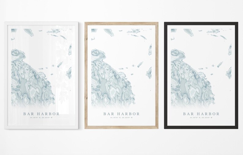 May include: Three framed prints of a map of Bar Harbor, Maine. The prints are in white, natural wood, and black frames. Each print features a blue and white topographic map of the area with the text "Bar Harbor" and coordinates.