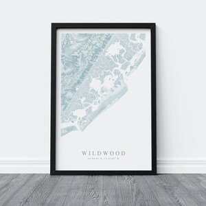 Może przedstawiać: Wydruk w ramie przedstawiający niebieską i białą mapę Wildwood w stanie New Jersey. Mapa pokazuje linię brzegową i okolicę. Pod mapą nadrukowano tekst "Wildwood" i wsp&oacute;łrzędne "39.0012&deg; N, 74.8149&deg; W".