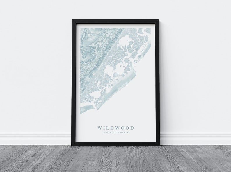 Może przedstawiać: Wydruk w ramie przedstawiający niebieską i białą mapę Wildwood w stanie New Jersey. Mapa pokazuje linię brzegową i okolicę. Pod mapą nadrukowano tekst "Wildwood" i wsp&oacute;łrzędne "39.0012&deg; N, 74.8149&deg; W".