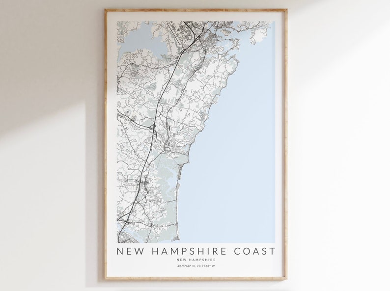 K&ouml;nnte beinhalten: Ein Schwarzwei&szlig;-Kartenabdruck der K&uuml;ste von New Hampshire mit hellblauem Hintergrund. Die Karte zeigt die K&uuml;ste und die umliegenden Gebiete. Der Text "NEW HAMPSHIRE COAST" ist unten auf der Karte gedruckt, zusammen mit den Koordinaten "43.2197&deg; N, 70.7168&deg; W".