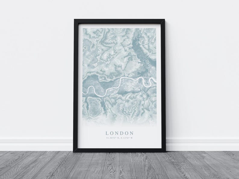 May include: A framed print of a map of London in blue and white. The map shows the Thames River winding through the city. The text "LONDON 51.5074&deg; N, 0.1278&deg; W" is printed below the map.