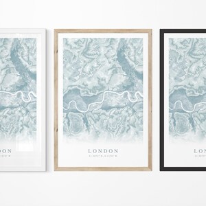 May include: Three framed prints of a map of London, each with a different colored frame: white, natural wood, and black. The map is a blue and white abstract design with the word "LONDON" and coordinates printed at the bottom.