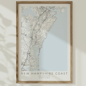 K&ouml;nnte beinhalten: Eine gerahmte Karte der K&uuml;ste von New Hampshire mit hellblauem Hintergrund und schwarzen Linien, die die Stra&szlig;en und Wasserwege zeigen. Der Text "NEW HAMPSHIRE COAST" ist unten auf der Karte gedruckt, zusammen mit den Koordinaten "43.3748&deg; N, 70.7348&deg; W".