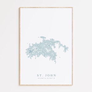 May include: A minimalist print of St. John, a US Virgin Island, with a blue topographic map design. The print includes the island's name and coordinates: "ST. JOHN 18.3248° N, 64.7281° W".