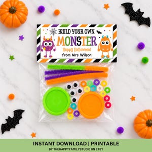 May include: A clear plastic bag containing a Build Your Own Monster craft kit with pipe cleaners, googly eyes, plastic rings, and two round lids. The header card features a purple and orange monster graphic with the text Build Your Own Monster Happy Halloween from Mrs Wilson.