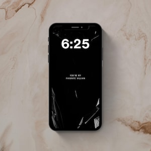 May include: A black smartphone displaying a digital lock screen with the time 6:25 in large white font and the text YOU'RE MY FAVORITE VILLAIN in smaller white letters. The screen background features a dark, glossy, crinkled texture effect.