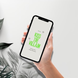 May include: A black smartphone displaying a light gray screen with the text KISS THE VILLAIN in bright green, distressed lettering. Above and below the title, smaller black text reads VILLAIN, GARETH CARSON, and KAYDEN LOCKWOOD.