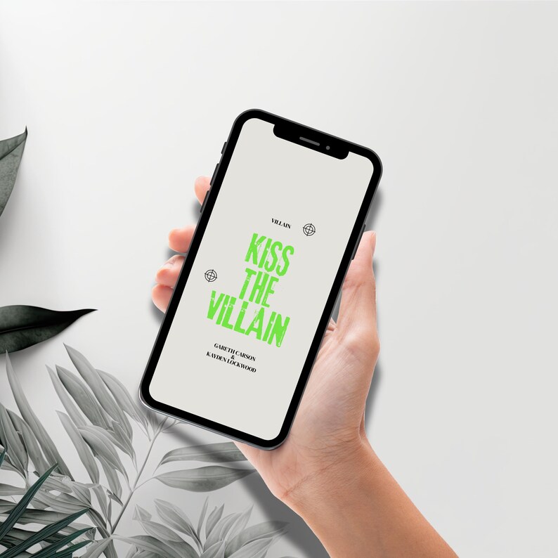 May include: A black smartphone displaying a light gray screen with the text KISS THE VILLAIN in bright green, distressed lettering. Above and below the title, smaller black text reads VILLAIN, GARETH CARSON, and KAYDEN LOCKWOOD.