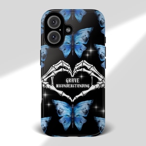 May include: Black phone case featuring a pattern of blue watercolor butterflies. The design includes a heart formed by white skeleton hands, with the text "GRAVE MISUNDERSTANDING" in the center.