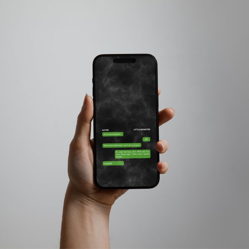 May include: A black smartphone displaying a dark, smoky background with a green text message conversation interface. The screen shows chat bubbles between Kayde and Little Monster, featuring text that includes phrases like You looked beautiful.